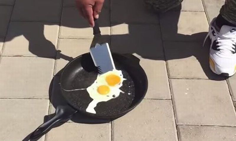 Cocinan un huevo frito en la vereda